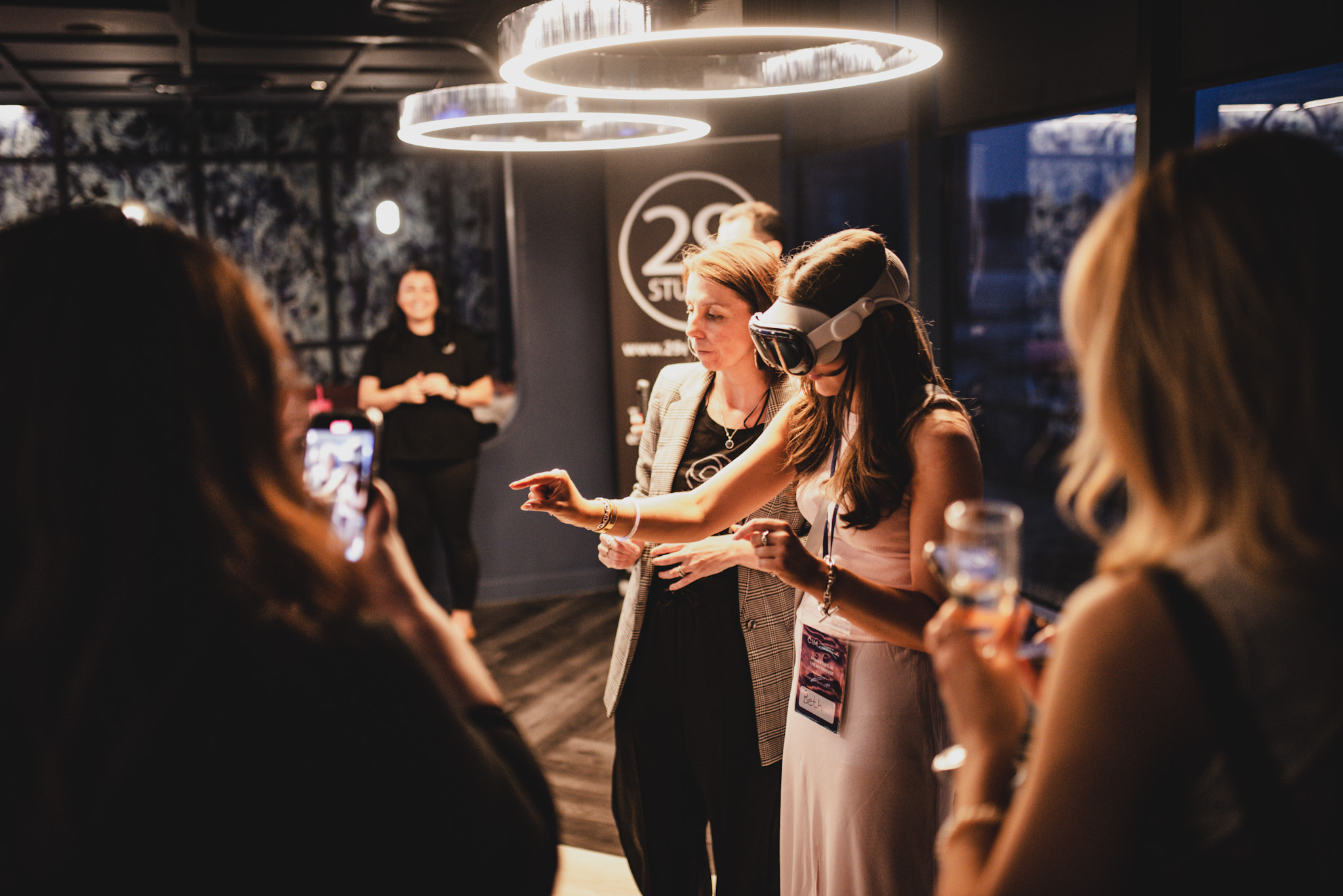 A woman wears a VR headset. She has her arms in front of her and looks to be carrying out a task that we cannot see.